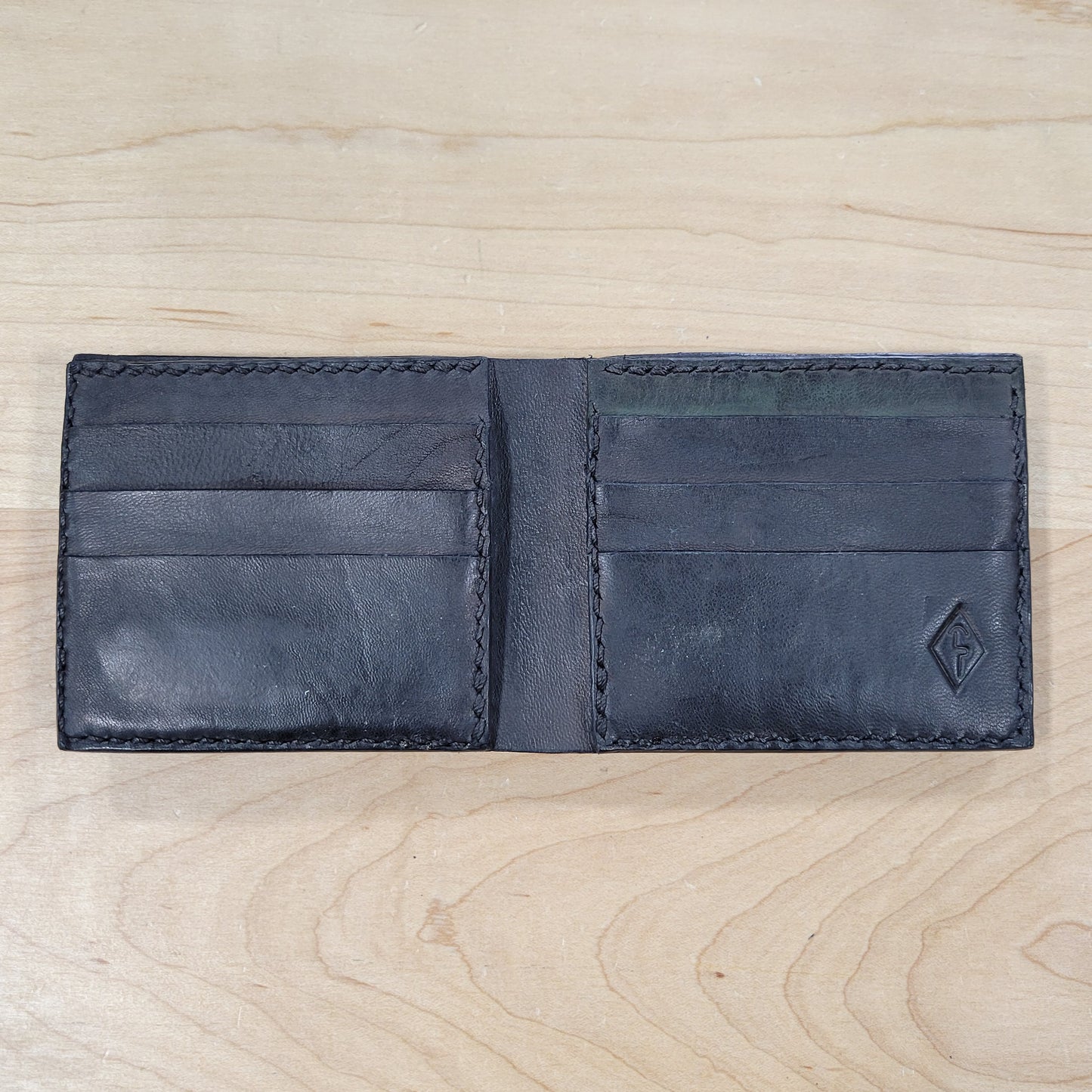 Our 4Bros Wallet is 100% hand-made in Cass County, Indiana. The single-fold design has four pockets on each side, three sized for credit cards, and one hidden pocket behind the card pockets. We use 5-6 ounce leather for the exterior and goat skin for the interior to keep the weight and thickness to a minimum.
