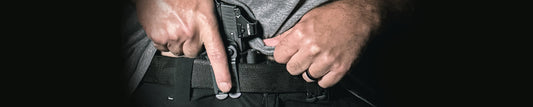 A person reaching into their holster.